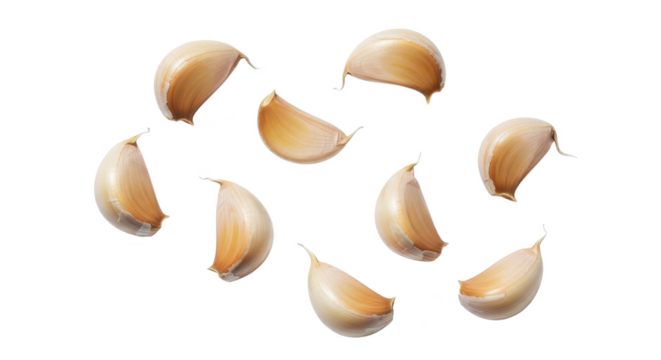 A natural arrangement of fresh, unpeeled garlic cloves scattered across a clean, isolated white background