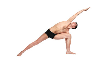 A man practices yoga by raising both arms up in a pose.