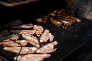 Enjoy the delightful experience of grilling both bacon and sausages on a BBQ grill
