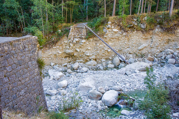 a destroyed bridge in the hiking area of the Restonica Valley with lots of debris 