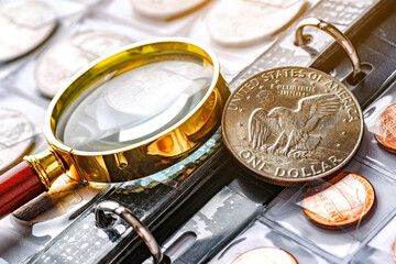Coins of the United States of America.Numismatics.Collection of ancient coins in an album.A collector holds an old coin.Magnifying glass.Antikvariat.