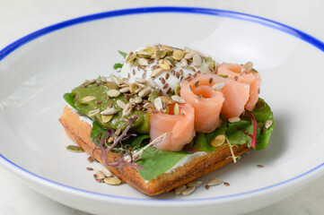 waffle with salmon, avocado, poached egg and seeds
