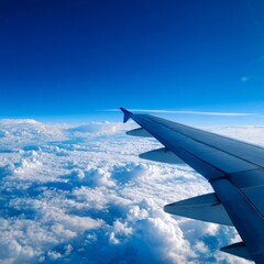 Fototapeta premium An aerial view of an airplane wing soaring above a fluffy, cloud-filled sky. The blue sky and fluffy clouds. Experience the wonder of flight from this unique perspective
