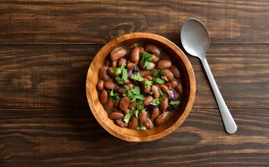 Baked beans in bowl on wooden background