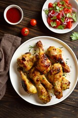 Roasted chicken drumsticks served with sauce and salad