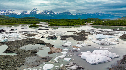 Aerial view of glacier lake with icebergs and mountains in Alaska. Gacier lake with floating...