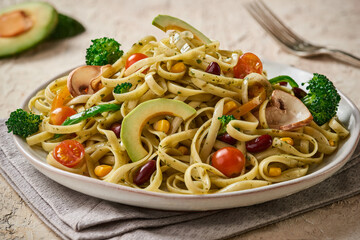Vegetables fettuccine pasta on a rustic wooden surface - closeup