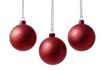 Three isolated, shiny, crimson Christmas ornaments hang with delicate strings, against black