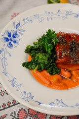 Baked meat with carrot puree and kale on a plate
