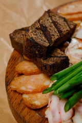 Meat appetizer with bread, onions and two sauces on a wooden board.