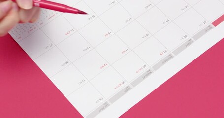 Chinese New Year Calendar Planning with Red Pen on Pink Background