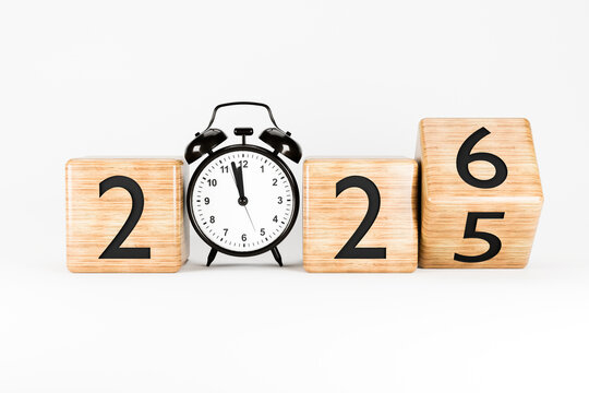 Wooden blocks showing the numbers 2025-2026 placed in front of a clock