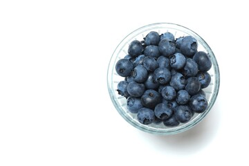 Glass bowl with fresh blueberries on the table