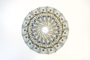 The money is laid out in the shape of a circle. Closeup of hundred dollar bills on white background