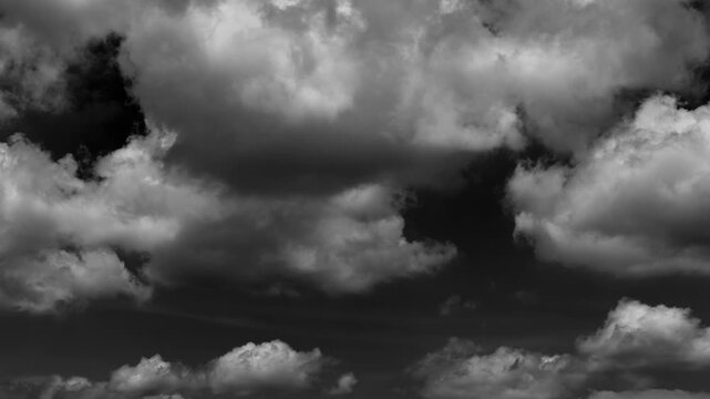 Time-lapse of White clouds move rapidly across a black sky background