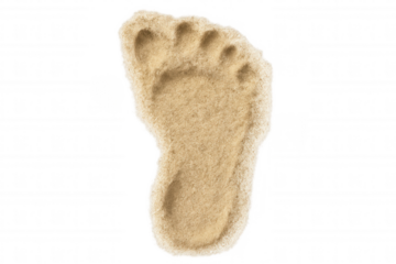 Footprint impression forming from sand, representing travel, journey, summer, and beach vacation concepts