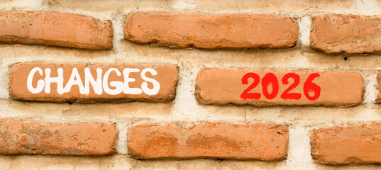 Obraz premium Changes 2026 symbol. Concept words Changes 2026 on beautiful brown brick wall. Beautiful brown brick wall background. Business and changes 2026 concept. Copy space.