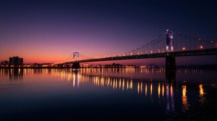 Fototapeta premium Sunset over the bridge reflecting in the water with city lights.