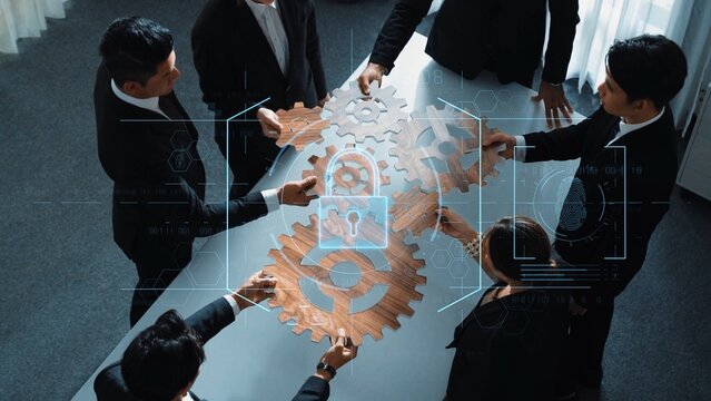 A diverse business team collaborates on innovative ideas using gears and a digital security overlay, showcasing teamwork and modern technology in a professional office. Raster - Powered by Adobe