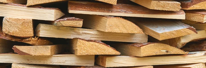 Selbstklebende Fototapeten Brennholz Stacked wood logs with varied grain patterns and natural texture for construction or firewood use.  © elenavolf