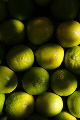 Overhead, full-frame close-up of a cluster of bright green and yellow-green limes