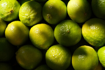 Overhead, full-frame close-up of a cluster of bright green and yellow-green limes