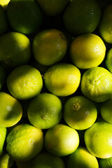 Overhead, full-frame close-up of a cluster of bright green and yellow-green limes