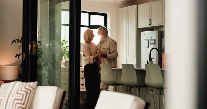 Commitment, senior couple and dance in home for anniversary celebration, holding hands and spin. Retirement, man and woman moving to music for love, smile and forehead touch with flare in kitchen