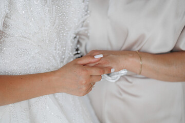 Bride and mother share a tender moment before the wedding ceremony at an elegant venue