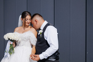 Couple shares a tender moment in front of a modern building during their wedding day