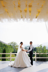 Couple exchanges vows in an outdoor ceremony surrounded by nature on a sunny day