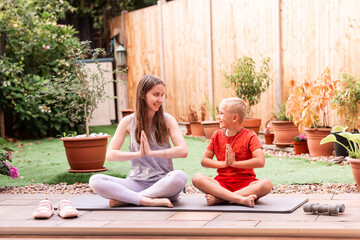 Teenage Girl and Boy Doing Yoga Together in Backyard. Family Fitness, Healthy Lifestyle