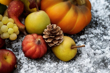 Autumn harvest bounty of fruits and pumpkins with pinecone