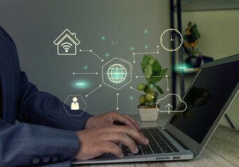 Businessman using a laptop with a futuristic UI to manage remote work, cloud data, and a global network, illustrating the concept of digital business transformation.