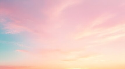 Obraz premium Soft pastel clouds drift across the sky during a serene sunset.