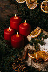 four burning Red advent candles in advent wreath decoration on wooden dark background. tradition in time before Christmas. xmas lights with christmas fir deco background concept. Festive still life.