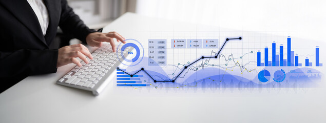 A business professional works on a keyboard while examining financial graphs and data analysis visuals, showcasing modern analytical strategies in a sleek office environment. Scalp