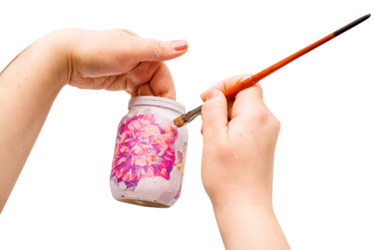 Decoupage bottle. The artist's hands with a brush paint on the bottle