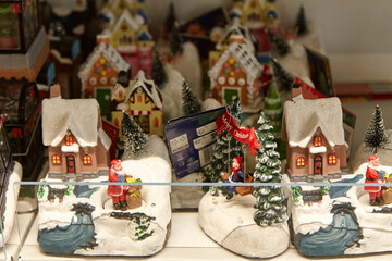 Christmas souvenirs displayed in a supermarket, featuring decorative miniature houses, Santa figurines, and festive trees, creating a joyful holiday shopping atmosphere with vibrant colors