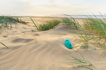 Footpath through dunes with footsteps, tracks in the sand between sedge bushes, footprints on the way, blowing grass in the wind, nobody, a lonely path by the North Sea, solitude