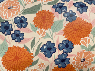Colorful floral pattern with orange, blue, and peach flowers and green leaves on a light background. Decorative botanical fabric texture, vintage floral wallpaper or textile design.