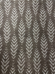 Brown woven fabric texture with light chevron pattern. Close-up of textile surface showing natural threads and geometric design, ideal background for decor, fashion, or interior projects.