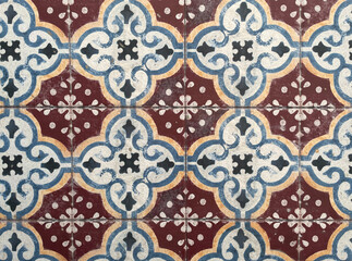 Vintage ceramic tile pattern with geometric floral motifs in blue, burgundy, and cream tones. Traditional Mediterranean design background for interior, architecture, and decor concepts.