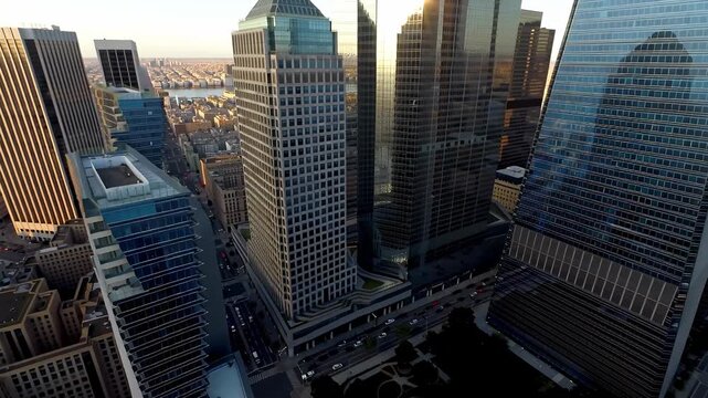 Aerial view of city with tall modern buildings and busy street traffic in daylight various vehicles driving on road urban environment with skyscraper reflections and sunlight on glass surfaces cha