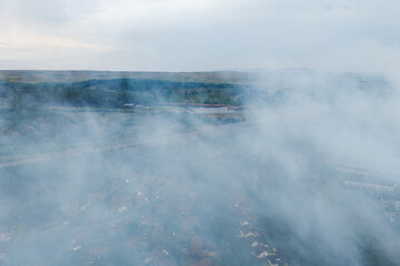 Aerial drone view of thick smoke from a moorland fire over a Welsh village