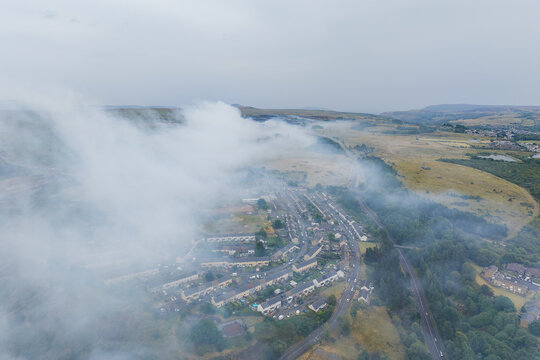 High angle view of wildfire smoke billowing across hills and a residential area