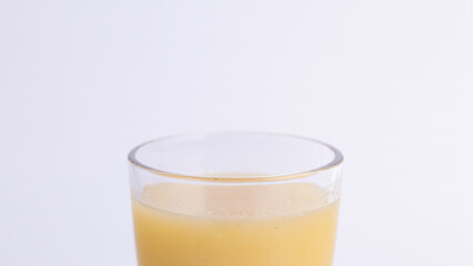 Fresh starfruit juice in a glass on white. Close-up tropical yellow beverage with copy space, healthy carambola smoothie or summer drink template for design.
