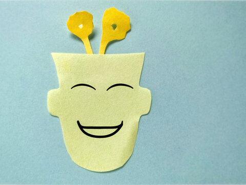 Creative paper art of human profiles symbolizing emotional intelligence with copy space. A head with smiling face and flowers representing growing mindset positivity. Mental health awareness concept - Powered by Adobe