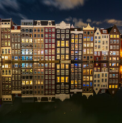 Charming Amsterdam houses bathed in the soft glow of the blue hour, peacefully nestled along the serene Keizersgracht street in Amsterdam, Netherlands