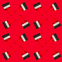Seamless pattern with large wide new red brush for construction or wall painting or canvas priming on a red background. Christmas wallpaper. Textured banner for a hardware store or art shop. Close-up.